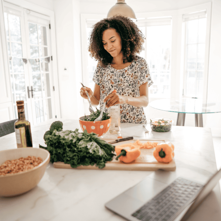 Healthy woman preparing a nutritious salad in a bright, modern kitchen, emphasizing wellness, healthy eating, and behavior change support.